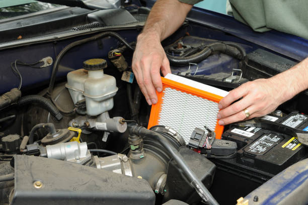 Man replacing a car’s air filter.