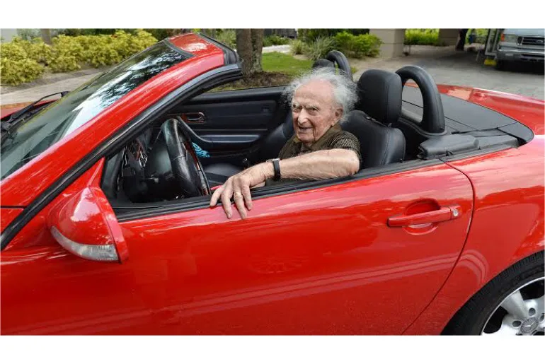 An image showing an old man driving a car.