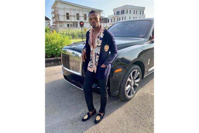 TundeWearsItAll pose with his Rolls Royce