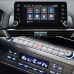 An image showing a button and touchscreen car infotainment display