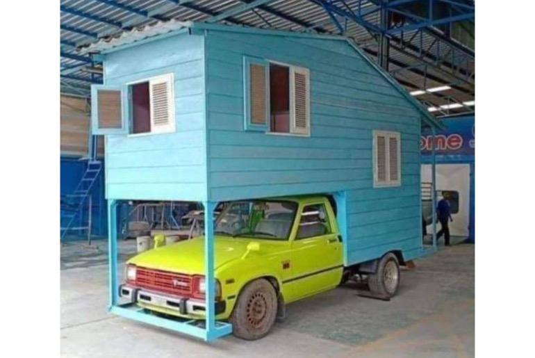 An image showing a car that has a house as roof.