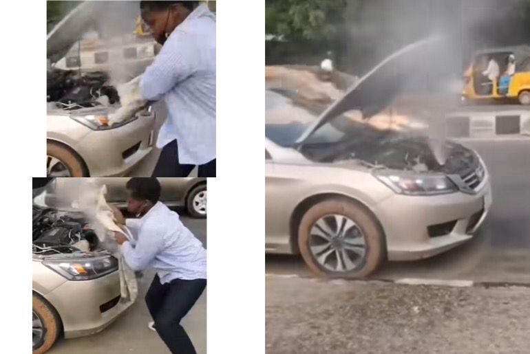 An image showing a man trying to quench the vapour of an overheating car.